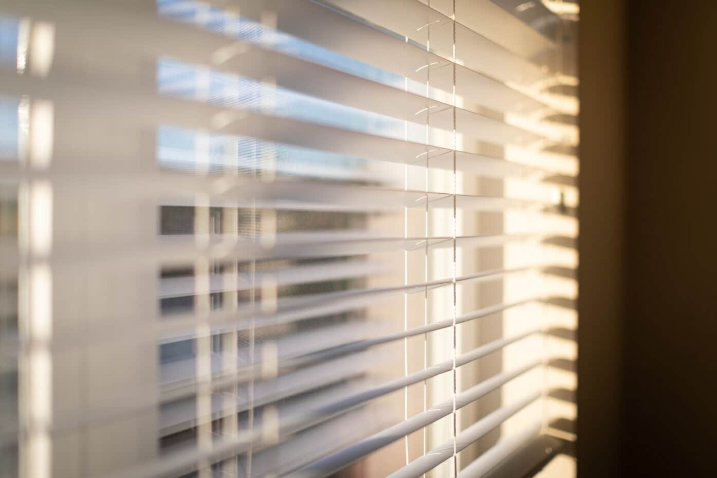 A window with open blinds, allowing light to enter the room.