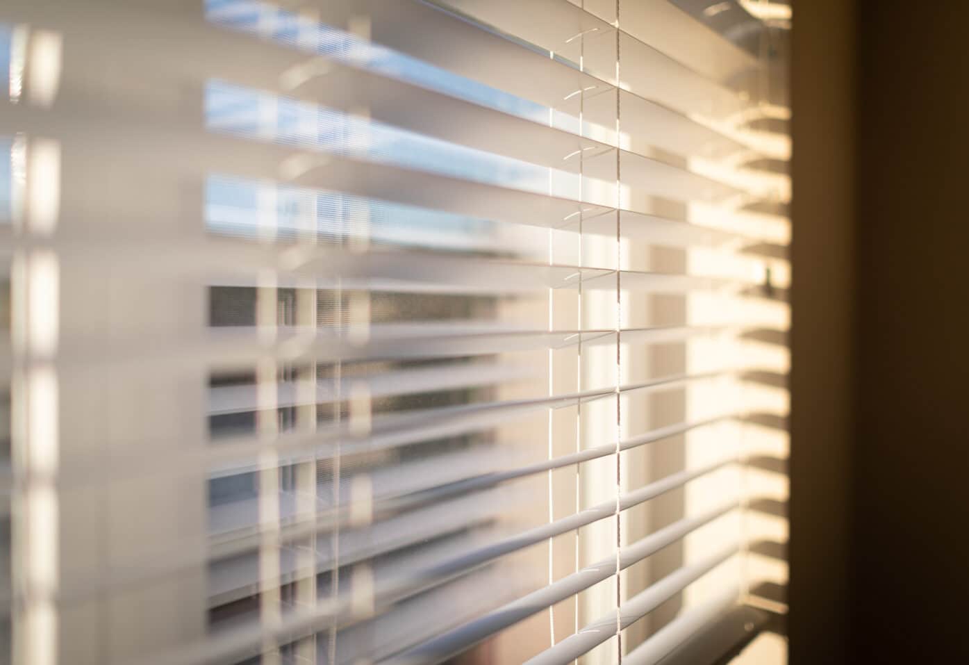 A window with open blinds, allowing light to enter the room.