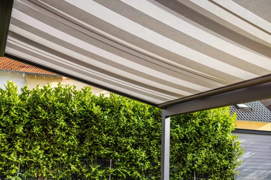 A patio featuring a canopy overhead and external blinds for shade and privacy.