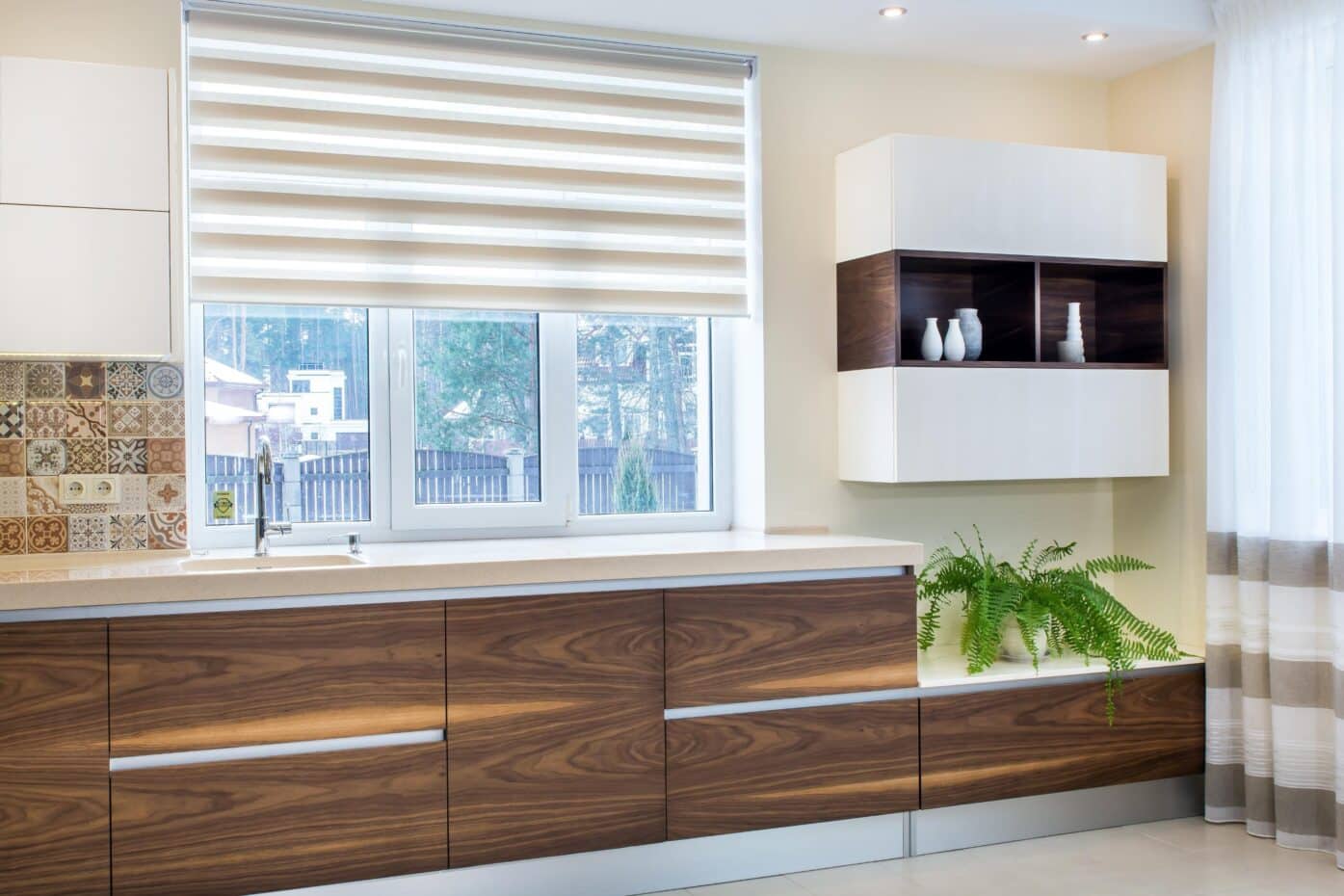 Modern kitchen featuring wooden cabinets, a window, and perfect fit blinds for a sleek, stylish look.